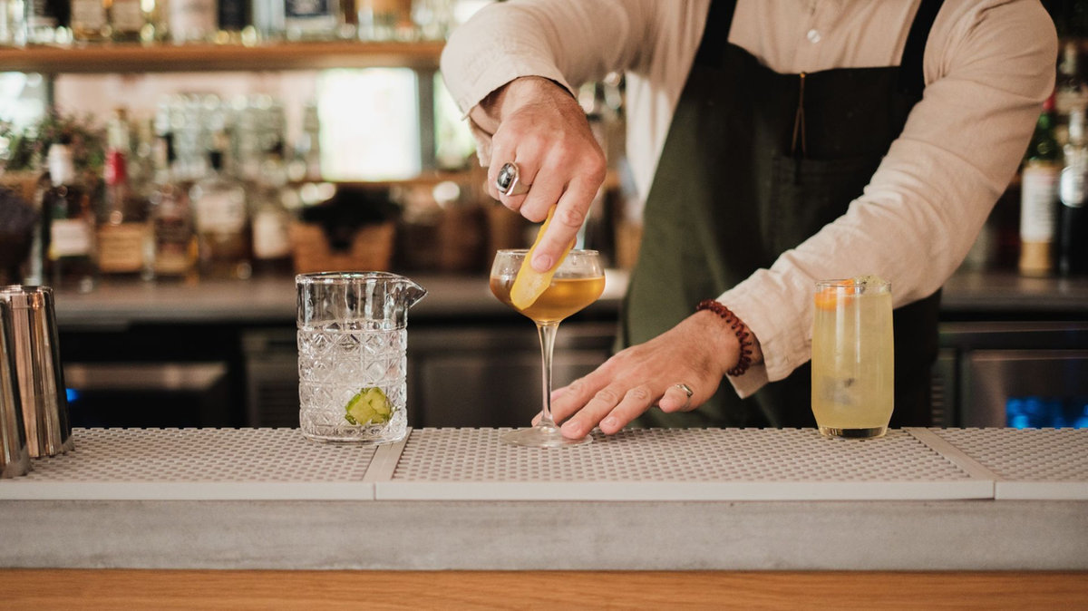 Licensed event bartender pouring a cocktail at a professionally staffed bar