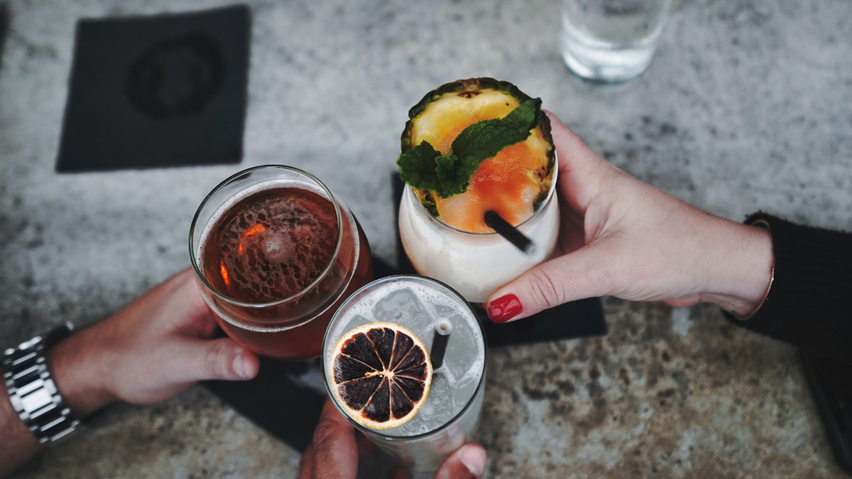Guests toasting craft cocktails served by a licensed event bartender