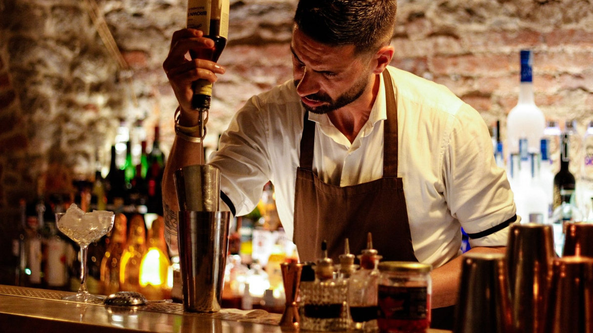 Licensed event bartender serving festive cocktails at a holiday party